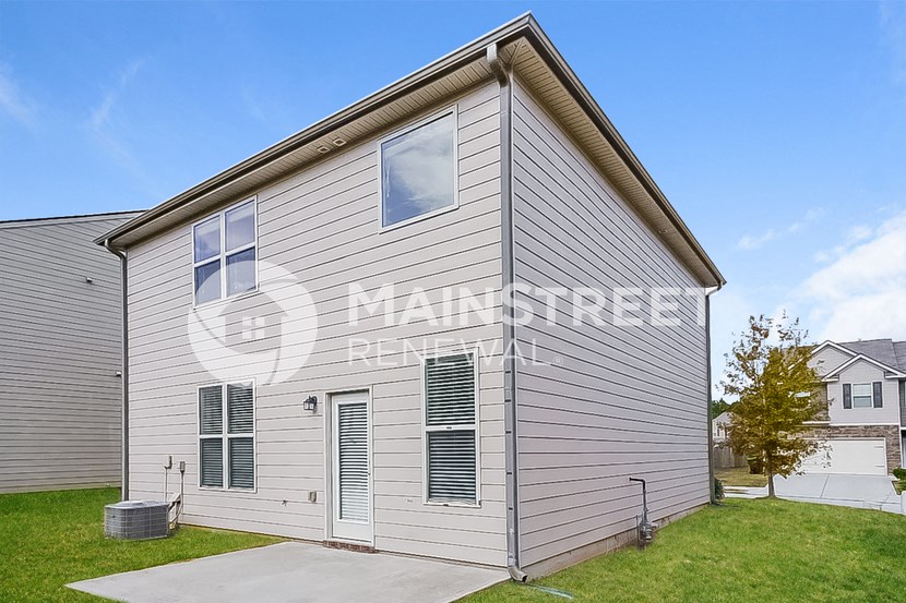 a white house with gray siding and green grass