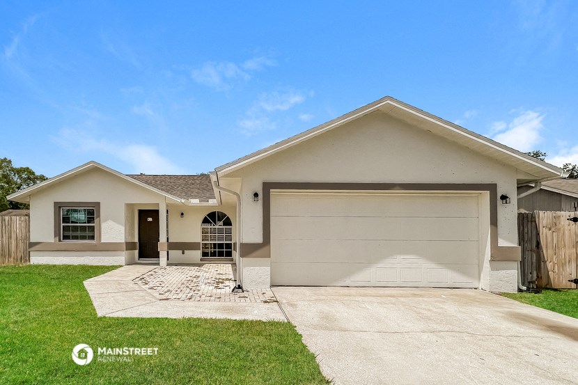a beige house with a driveway and a garage door