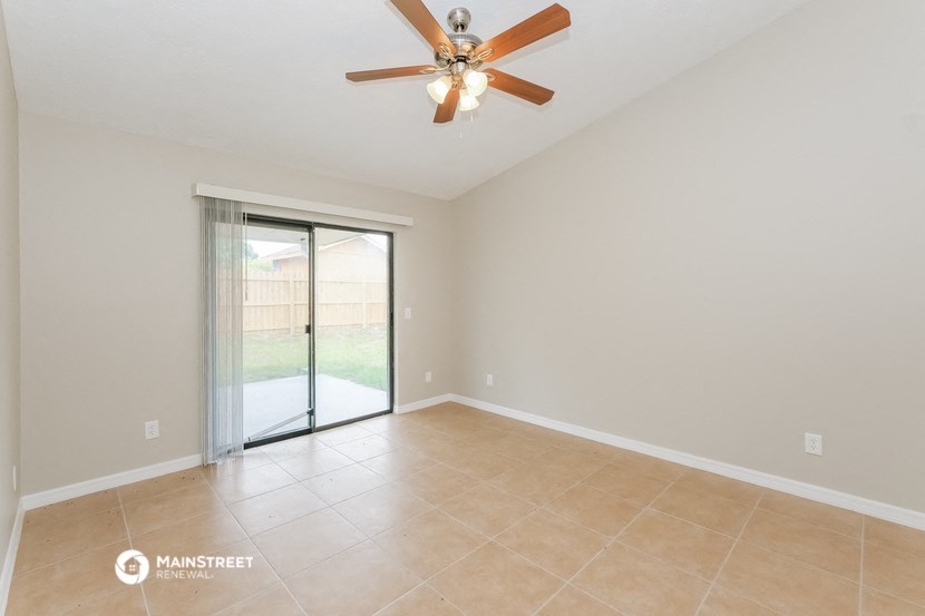 the spacious living room with sliding glass doors to the backyard