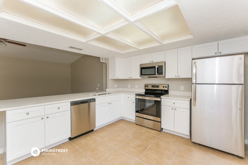 a kitchen with white cabinets and stainless steel appliances
