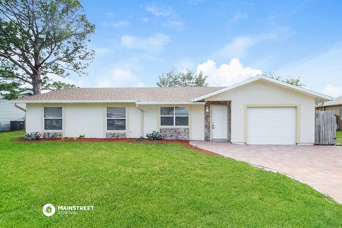 a white house with a lawn and a garage