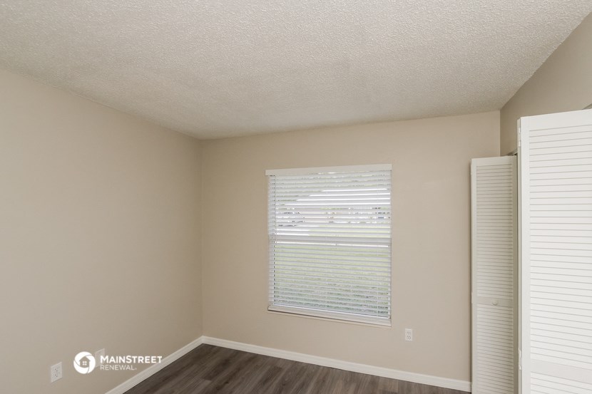 the spacious living room of an apartment with a large window