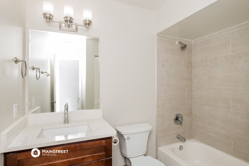 a bathroom with a sink toilet and a shower and a mirror
