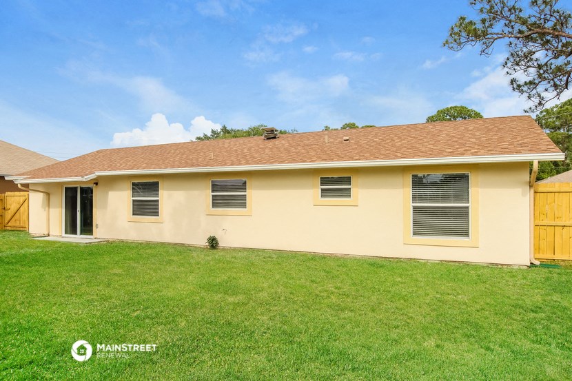 the front of a yellow house with a green lawn