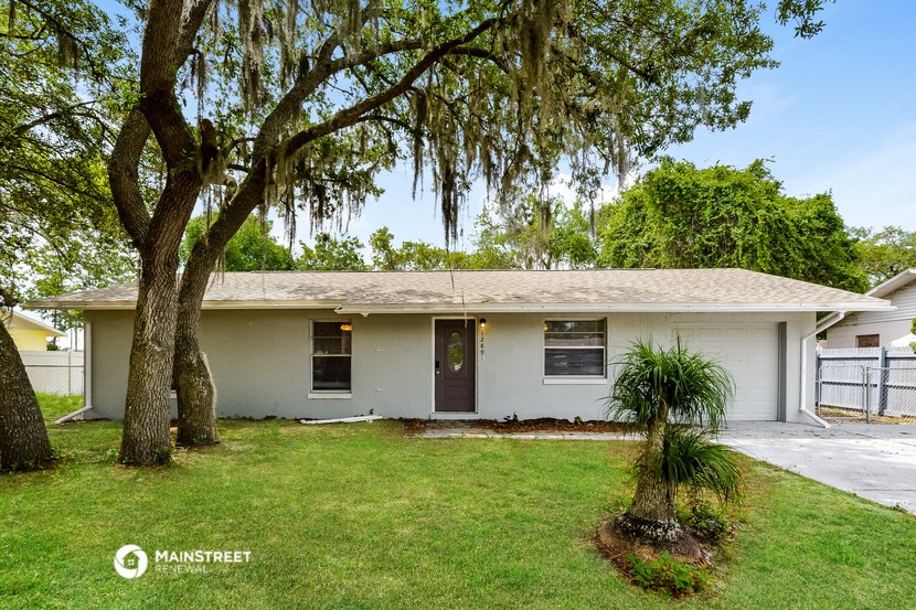 a white house with a yard and trees