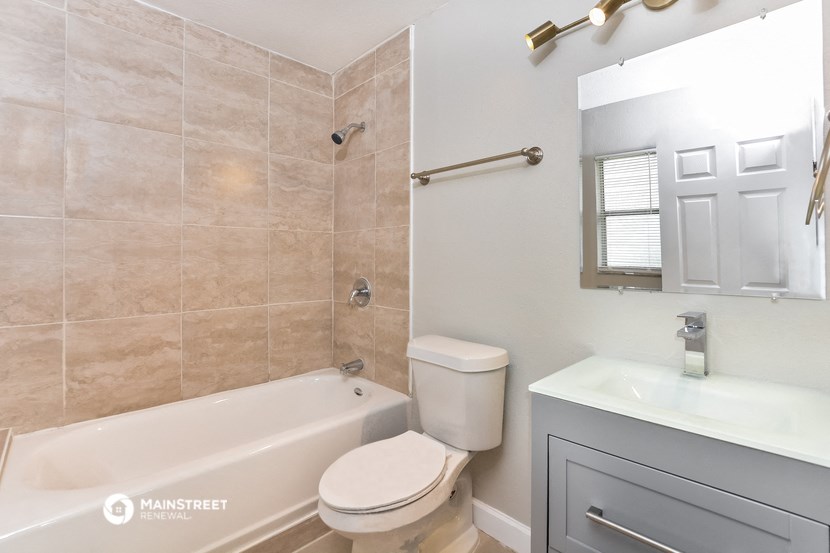 a bathroom with a tub and a sink and a toilet