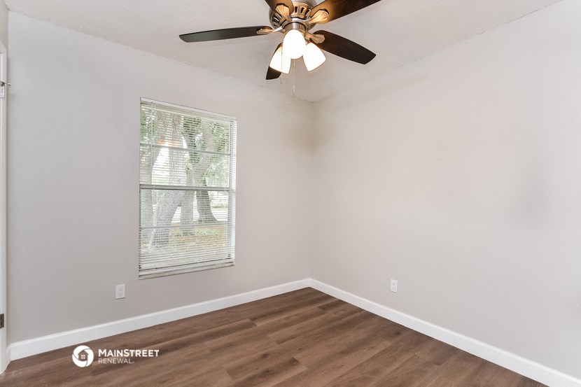 the living room of our studio apartment atrium with a ceiling fan