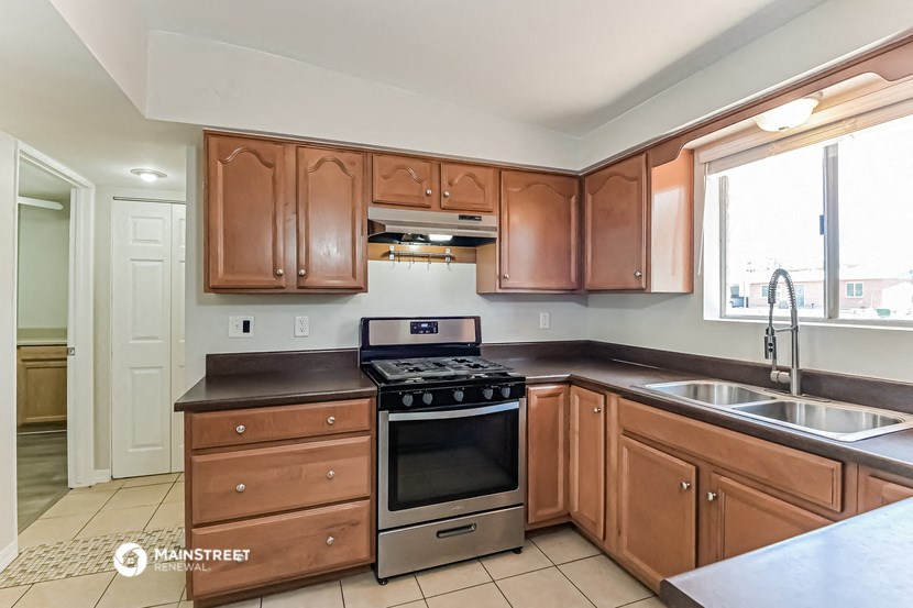a kitchen with wooden cabinets and a stove and a sink