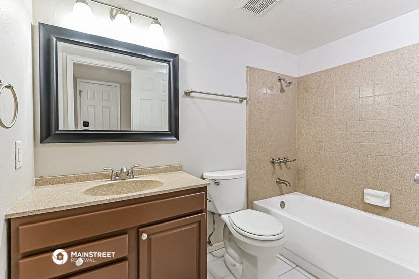 a bathroom with a sink toilet and tub and a mirror