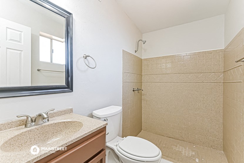 a bathroom with a toilet and a sink and a mirror