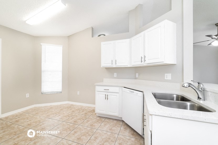 an empty kitchen with white cabinets and a sink