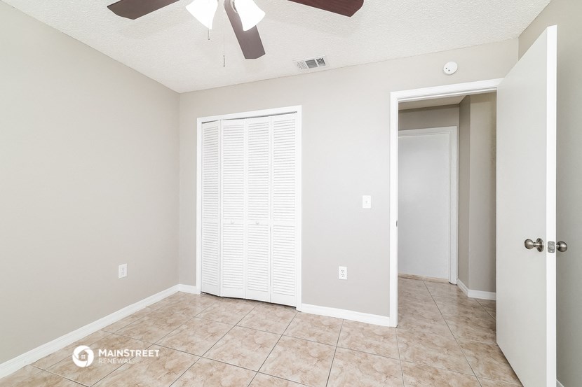 an empty living room with a closet and a door to a bathroom