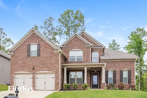 a brick house with white garage doors