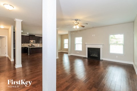 an empty living room with wood floors and a fireplace