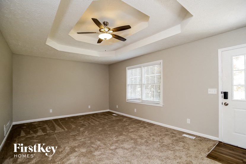 the master bedroom has a ceiling fan and a carpeted floor