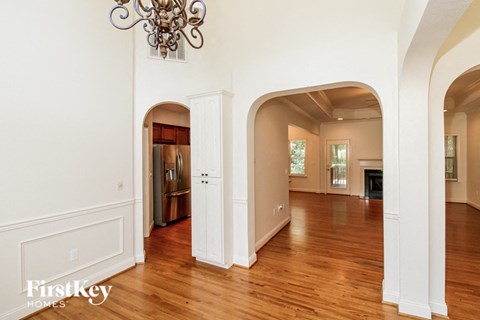 A large open room with arched doorways and a chandelier.