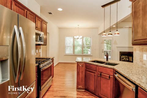 A kitchen with wooden cabinets and a stainless steel refrigerator.