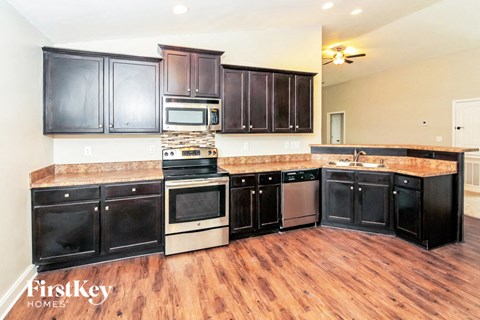 a large kitchen with black cabinets and a wood floor