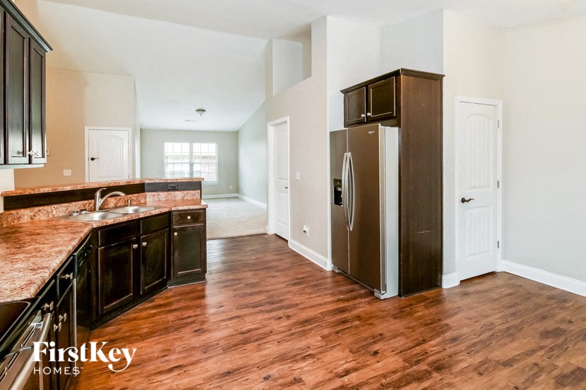 a kitchen with a stainless steel refrigerator and a wooden floor