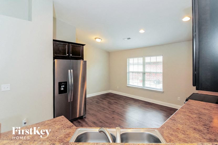 a kitchen with a stainless steel refrigerator and a window
