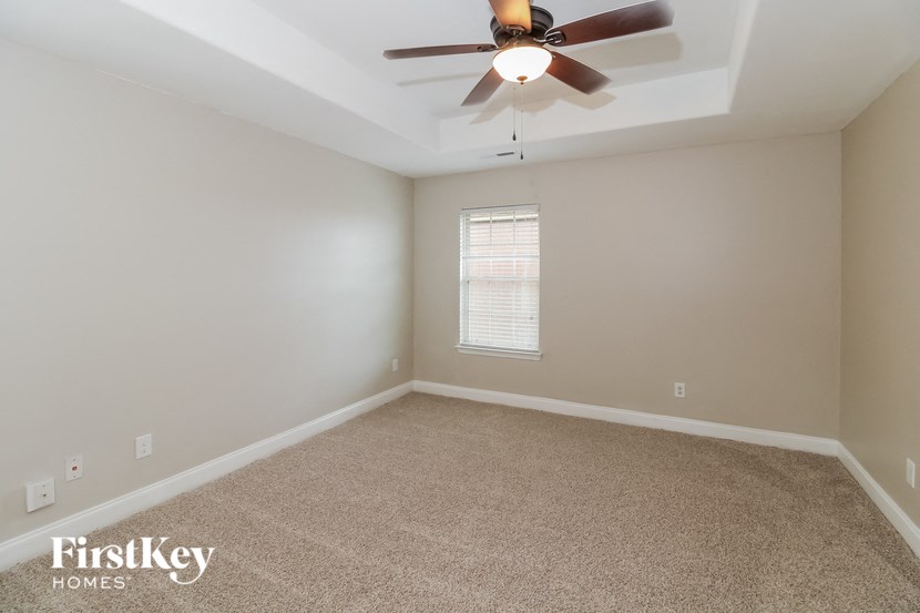 an empty room with a ceiling fan and a window