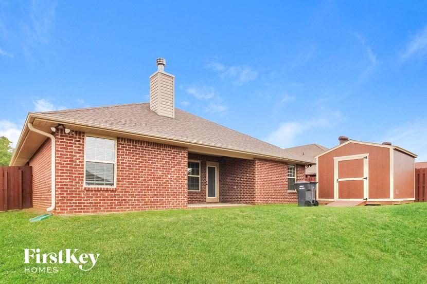 a red brick house with a green lawn