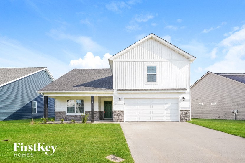 a white house with a white garage door and a lawn
