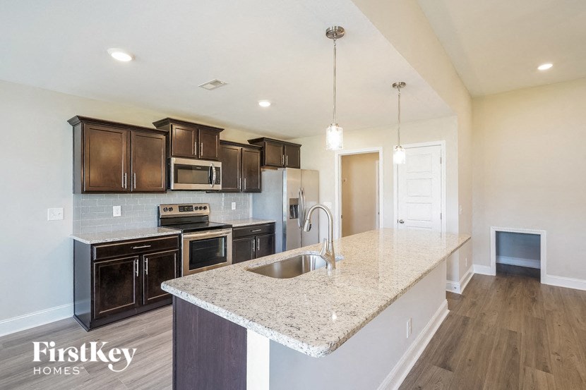 a kitchen with black cabinets and a granite counter top