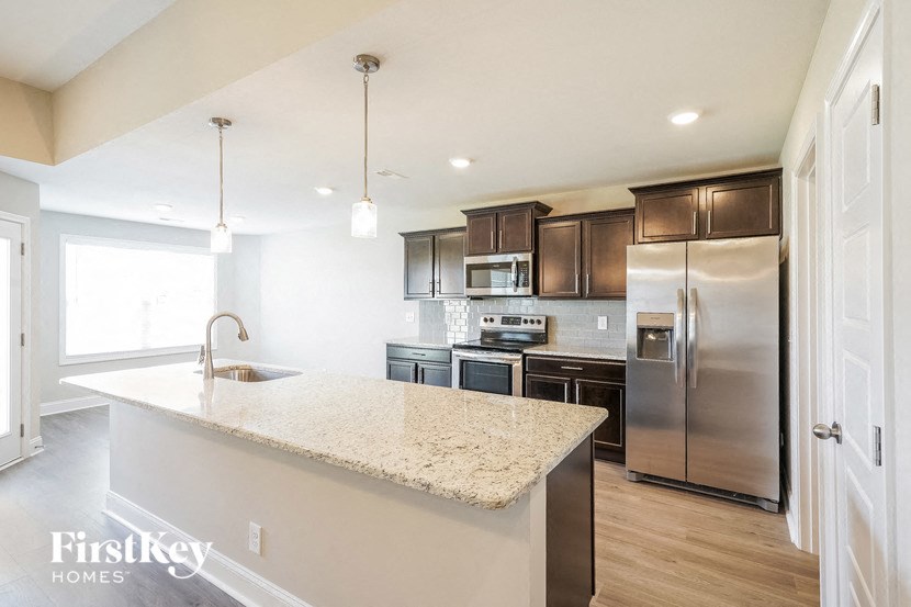 a kitchen with stainless steel appliances and a marble counter top