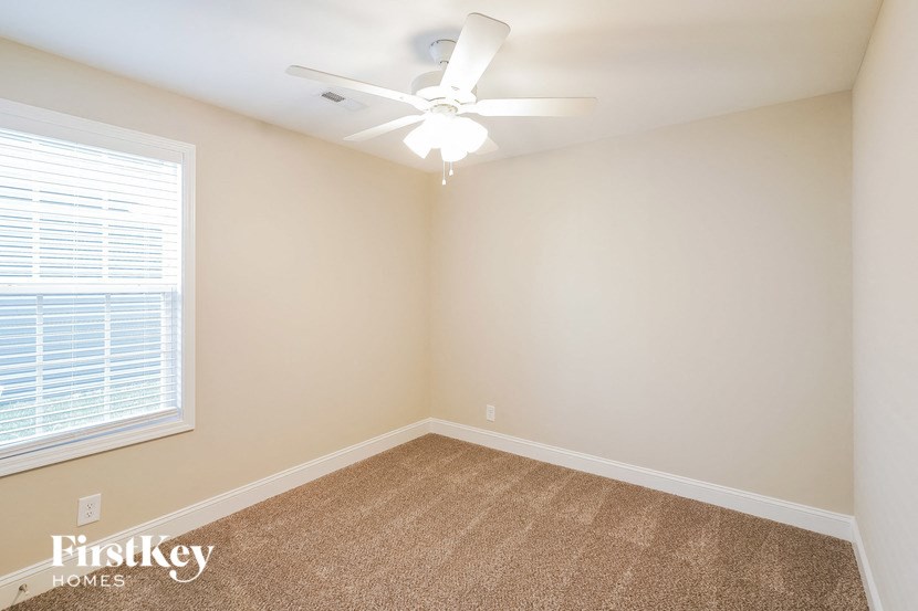 a bedroom with a ceiling fan and a window
