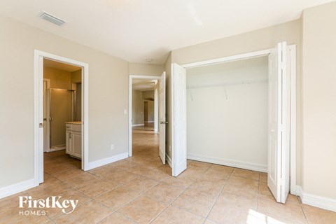 a bedroom with two closets and a hallway to a bathroom and a closet