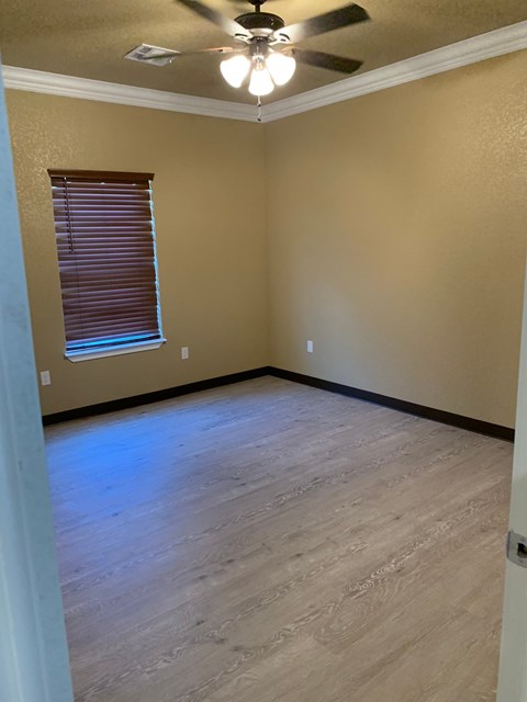 a living room with a wood floor and a ceiling fan