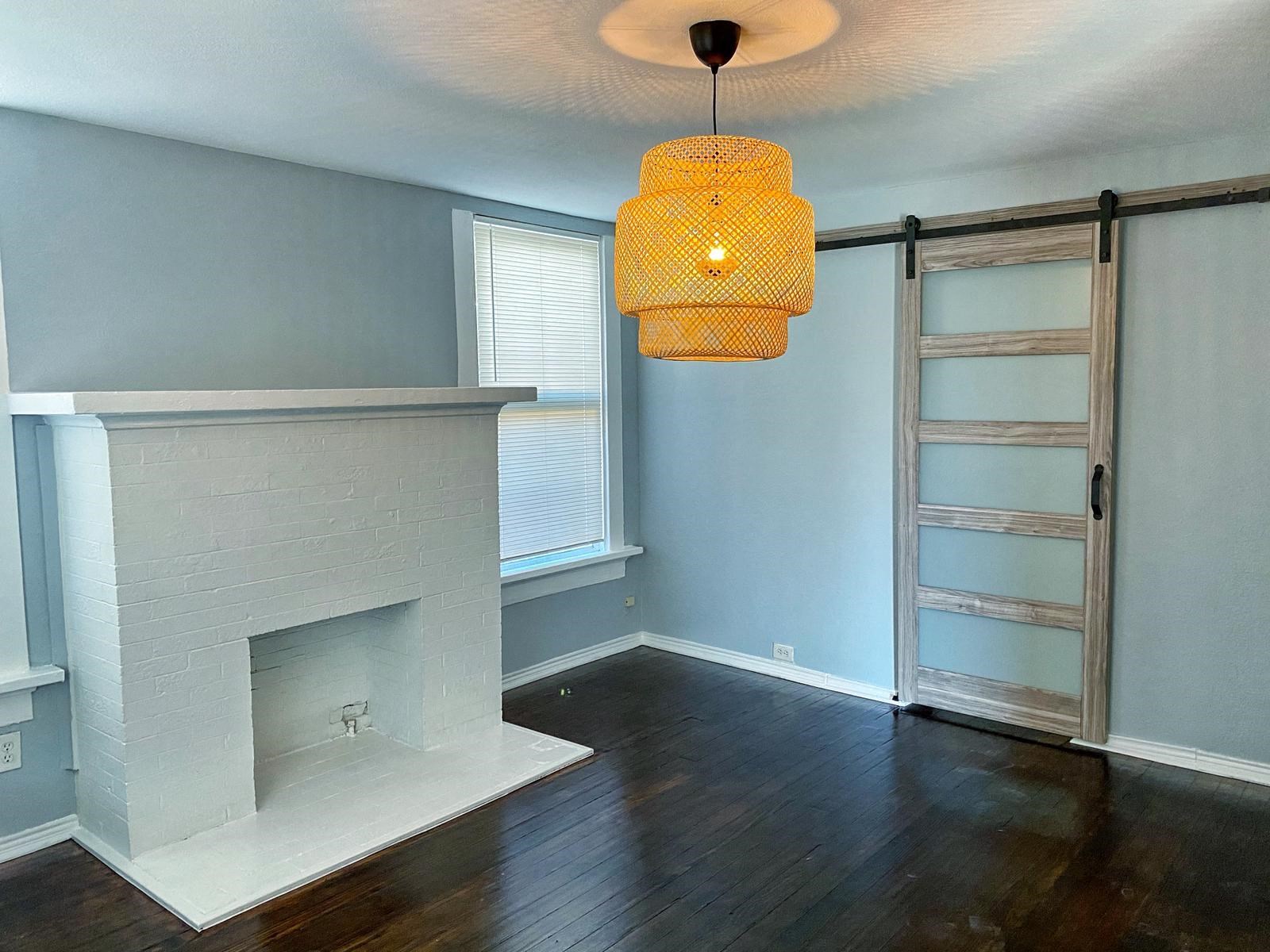a living room with a fireplace and a sliding barn door