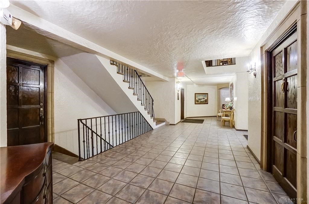 the hallway of a house with a staircase and a tiled floor