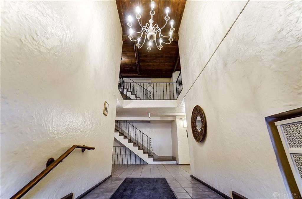 the lobby of a house with a staircase and a chandelier