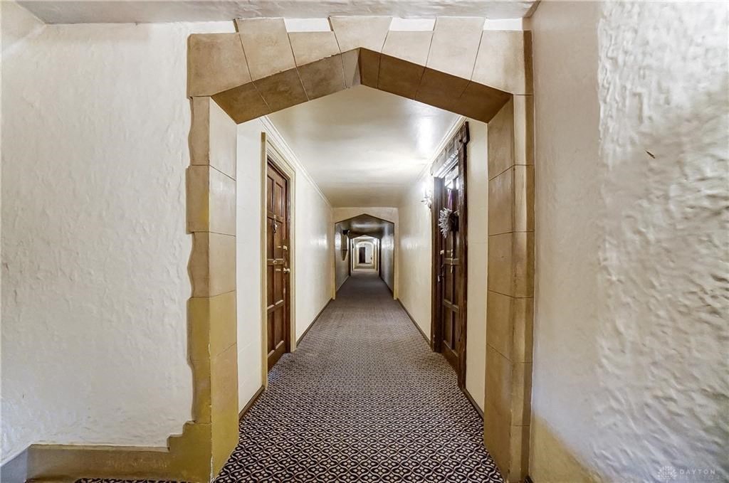 the hallway of a hotel with a long hallway with doors