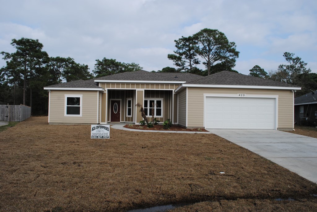 a beige house with a driveway and a garage door