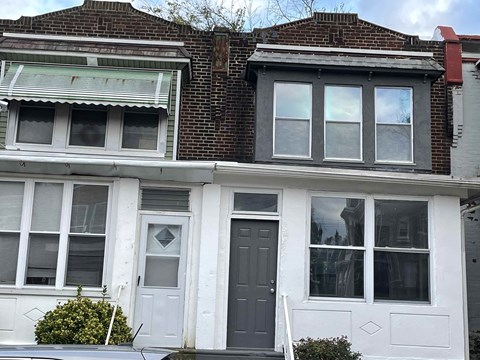 A white house with a black door and windows.