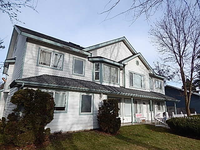 A two-story house with a white exterior and a grey roof.