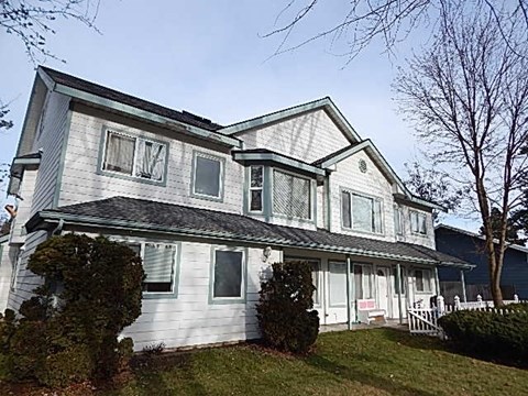 a white house with a porch and a yard