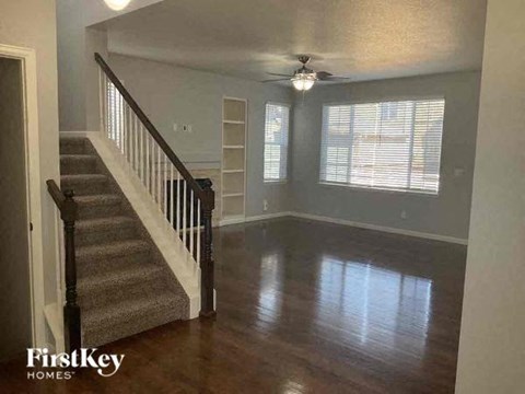 a living room with a staircase and a ceiling fan
