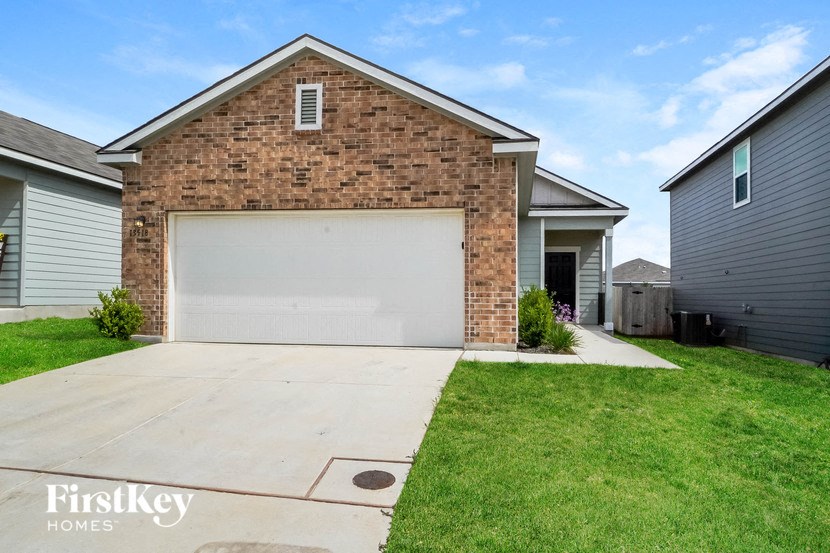 a white garage door in front of a brick house