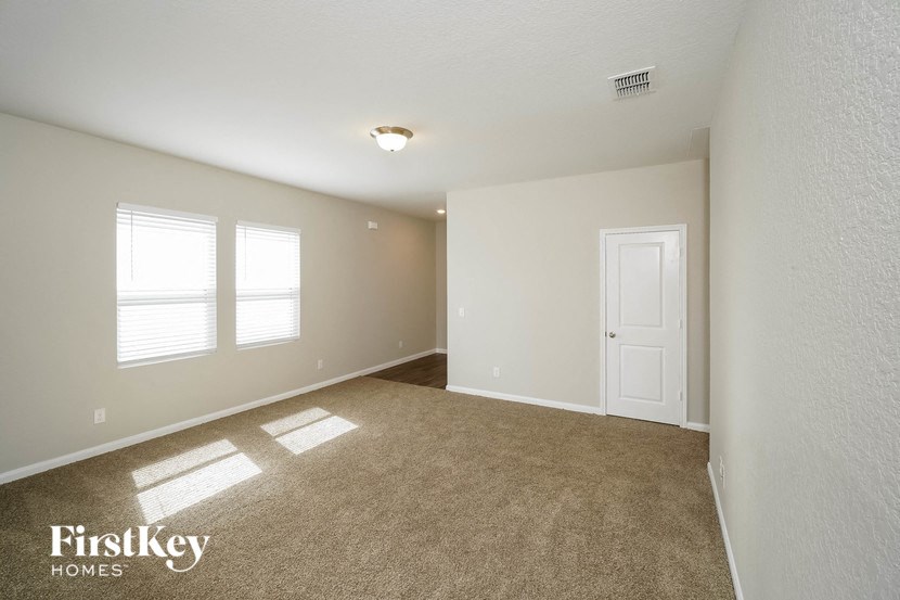 an empty living room with a white door and window