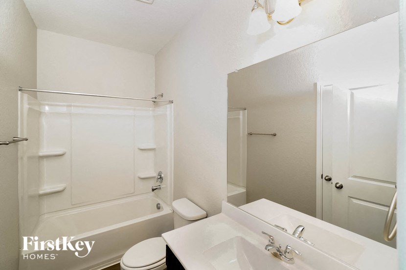 a bathroom with a sink and a tub and a mirror