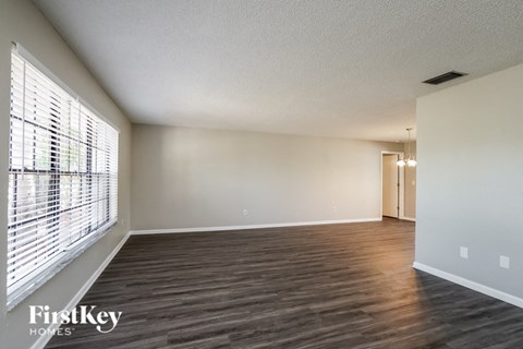an empty living room with wood flooring and a large window