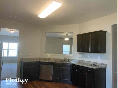 a kitchen with black cabinets and a sink and a mirror