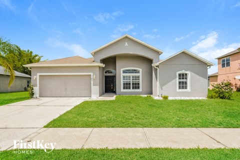 a beige house with a lawn in front of it