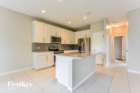 a large kitchen with white cabinets and a counter top