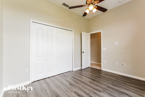 a bedroom with a ceiling fan and a closet
