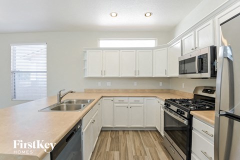 a kitchen with white cabinets and stainless steel appliances
